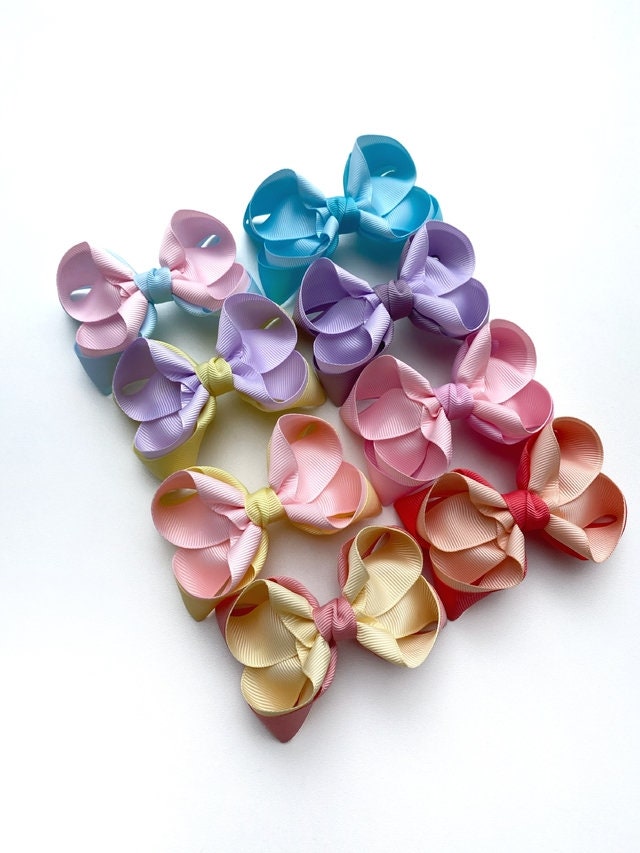 Colorful hair bows arranged in a circular pattern on a white background